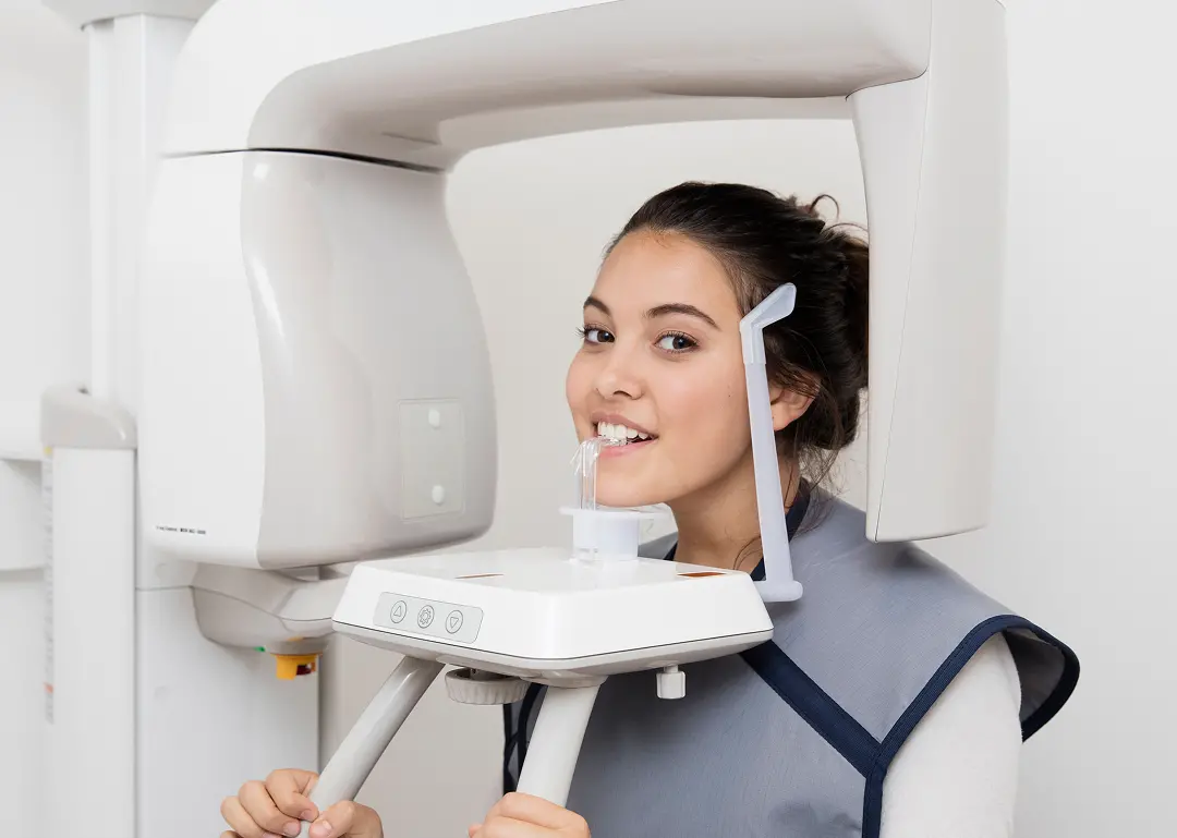 weiblicher Teenager steht im modernsten DVT Gerät für maximale Strahlenreduktion der Röntgenaufnahme