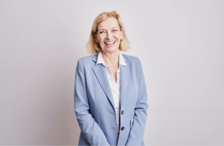 Eine ältere Dame im mittleren Alter mit attraktiven Lächeln dank Kieferorthopädie Wolfratshausen.