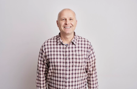 Erwachsener mit attraktivem Lächenl und harmonischen Zahnkontakten dank ganzheitlicher und funktioneller Kieferorthopädie Wolfratshausen und Osteopathie München Süd